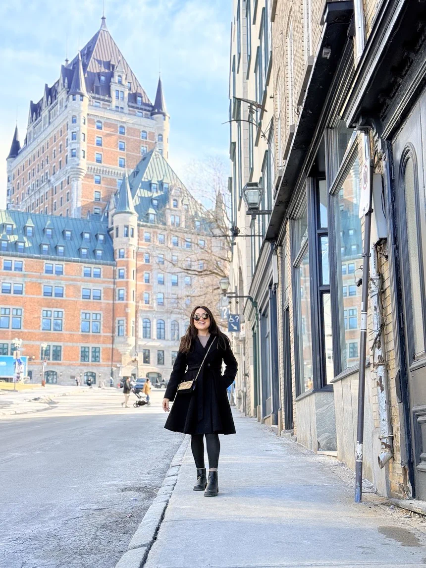 Camila caminhando em Quebec City, com o Château Frontenac ao fundo